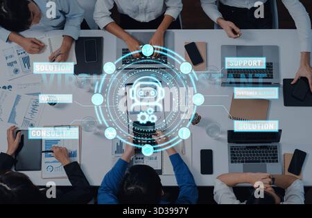 Professionals engage in a collaborative meeting around a table, utilizing virtual assistant technology to enhance business strategies and optimize Stock Photo