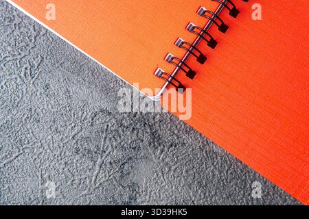 Orange Spiral Notebook on a Dark Gray Textured Background Stock Photo
