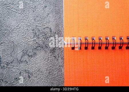 Orange Spiral Notebook on a Dark Gray Textured Background Stock Photo