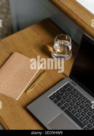 Cozy home office aesthetic with warm brown table and laptop Stock Photo