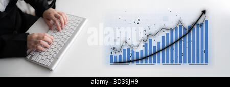 A business professional focuses on keyboard input, analyzing financial data trends shown in a graph, illustrating steady growth and performance in the Stock Photo