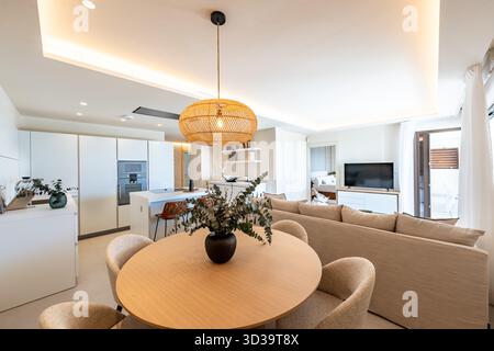 Open plan living room and kitchen with dining area in holiday apartment Stock Photo