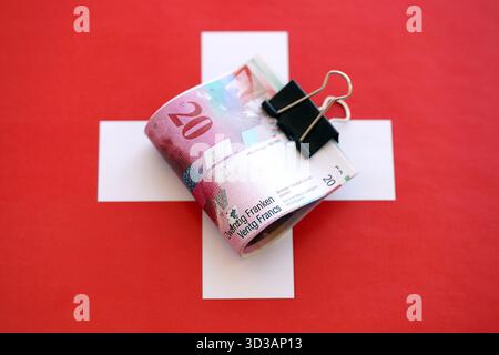 Swiss franc banknotes and flag. The current francs money bills lies on flag in big amount. The concept of business in Switzerland Stock Photo