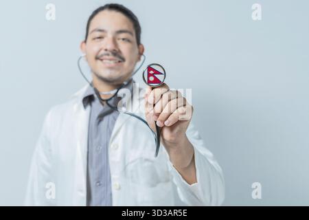 Smiling doctor showing stethoscope with Nepal flag. Nepal national healthcare Stock Photo
