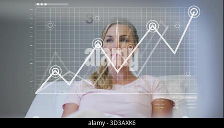 Displaying mature woman sitting on light sofa in lounge, with digital line chart showing data nodes Stock Photo