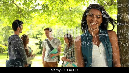 Leaning female student smiling against tree trunk on campus lawn, with notebooks, copy space Stock Photo