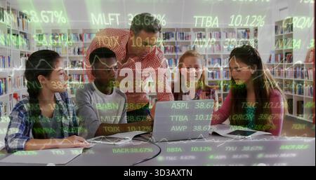 Mature teacher guiding four students at laptop in library, with notebooks and green stock ticker Stock Photo