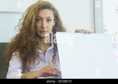 Reputable mature business woman folding notebook after she finished work successfull, poised, calm, accomplishment, after work, finished digital onlin Stock Photo