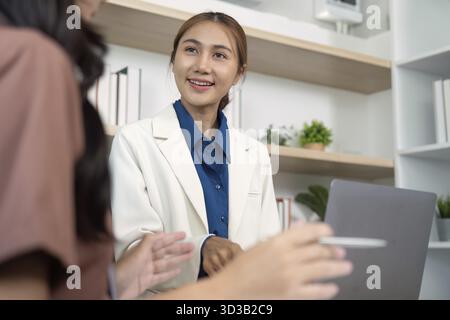 A friendly discussion between two colleagues about project progress, highlighting teamwork and positive communication Stock Photo
