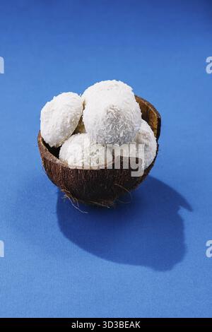 Food, Coconuts with candies on blue background Stock Photo