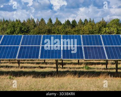 Somerset, UK - Sep 04 2025: Rows of photovoltaic panels in a rural field beneath scattered clouds, Somerset, UK, bright afternoon, clean energy and sustainability concept. Stock Photo