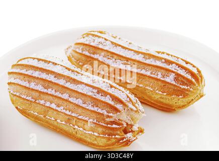 Food, Two eclairs on white plate isolated Stock Photo