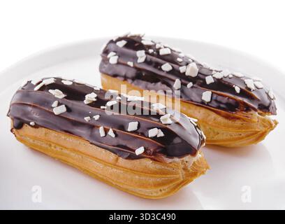 Food, Two eclairs with chocolate glaze in white plate Stock Photo