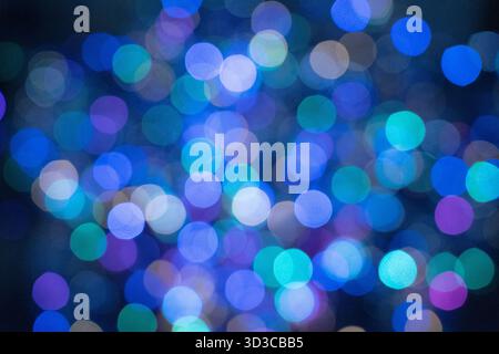 A soft-focus image showing a beautiful mix of blue, teal, and purple bokeh lights, creating a dreamy and abstract background perfect for festive, crea Stock Photo