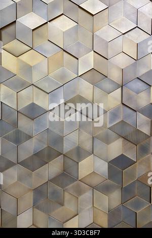 A close-up image of a metallic 3D geometric wall design with hexagonal cube-like shapes. The pattern creates a modern and elegant visual effect ideal Stock Photo