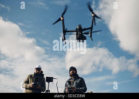 Man pilot controlling quadcopter drone with remote controller pad Stock Photo
