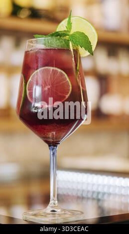 Food, Cold pink cocktail with fresh grapefruit, lime and ice cubes on restaurant table Stock Photo