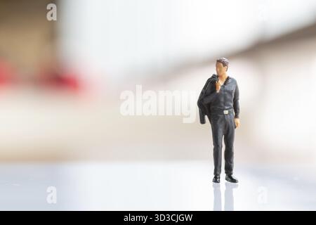 Miniature people : Businessman standing on empty space for text Stock Photo