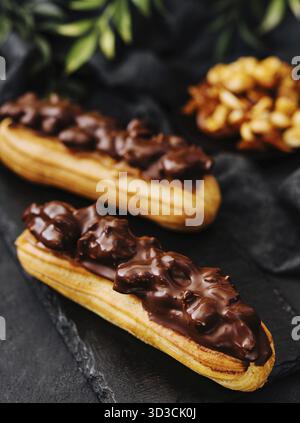 Food, Two eclairs with dark chocolate on black board Stock Photo