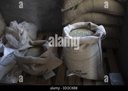 Green coffee beans in burlap sack at roaster company Stock Photo