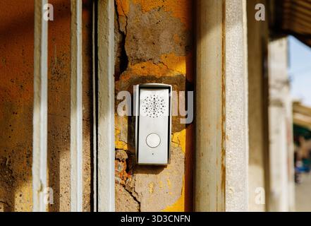 Weathered wall with modern intercom device on painted surface. Stock Photo