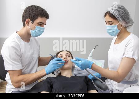 Group of students in dental clinic learn watching dental treatment with microscope Stock Photo