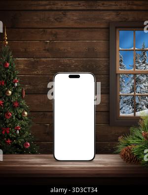 Smartphone with blank screen standing on wooden table, Christmas tree and snowy window background, cozy cabin interior, festive digital concept Stock Photo