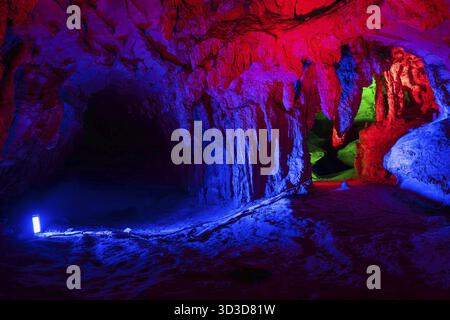 Lit in blue and red lights stunning interior of the beautiful Huanglong Yellow Dragon Cave called also the Wonder of the World's Caves, Zhangjiajie, H Stock Photo