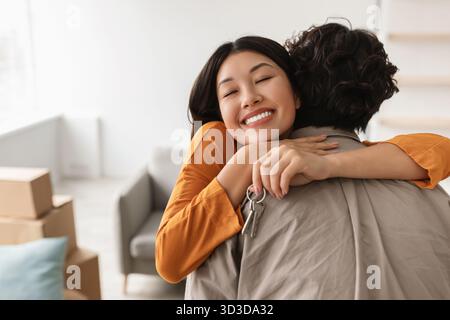 Happy Couple Celebrating New Home With House Key on Moving Day Indoors in Their Apartment Stock Photo