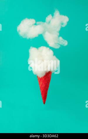 Clouds emerging from a red ice cream cone on a vibrant blue background. Growth, future, development concept. Minimal futuristic composition. Stock Photo