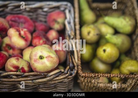 Nectarines and pears in wicker basket on display on a stall at farmers market in Cornwall, Uk Stock Photo