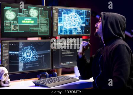 Cheerful man delighted after stealing sensitive information using VPN on dark web. Hacker doing victory hand gesture after seeing access granted message, breaking into systems to take restricted data Stock Photo