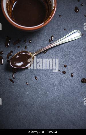 Melted hot dark chocolate, copy space border background on dark slate Stock Photo