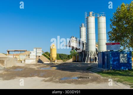 Concrete batching plant on the outskirts of Paks, Hungary — silos, aggregate piles and mixing equipment at a ready-mix production site. Stock Photo