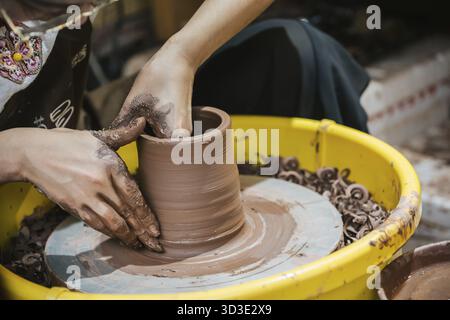 Chongqing, China - August 2019 : Female worker sitting in a workshop making ceramic pottery for sale, Ci Qi Kou Old town Stock Photo