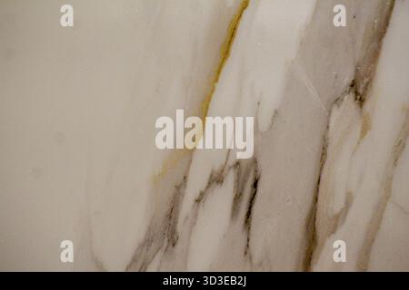 Artistic marble texture in soft white tones with golden and gray streaks, ideal for abstract design projects. Stock Photo