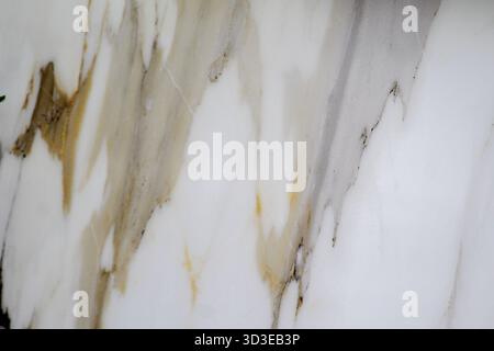 Close-up view of a white marble slab with natural golden and gray vein patterns. Perfect for architecture and 3D models. Stock Photo