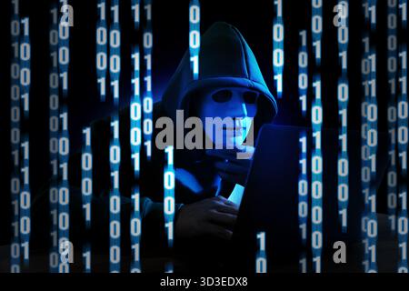 Cyber attack. Hacker in mask using laptop. Blue glowing binary code around him Stock Photo