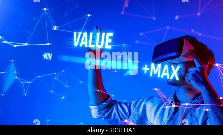 A young man wearing a virtual reality headset interacts with a digital environment, exploring concepts of value and potential with vibrant graphics Stock Photo