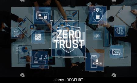 A high-angle view of a business meeting focused on cybersecurity. Professionals discuss the Zero Trust model, sharing insights on data protection and Stock Photo