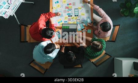 Top view of smart creative project manager using laptop working on Ux Ui design for mobile phone interface while marketing team designing software Stock Photo