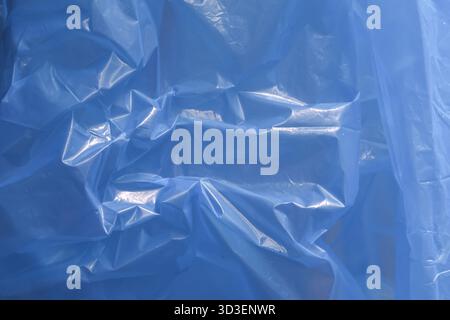 Serene blue plastic sheet background with an abstract texture. This material surface pattern reflects light, creating calm and cool visual for variety Stock Photo
