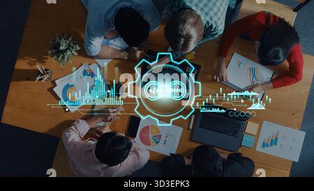 A dynamic scene depicting a team engaged in data analysis and strategic planning, featuring technology elements and infographics in a modern office Stock Photo