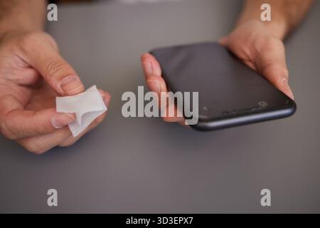 Close up on hands man female holding mobile smart phone in hand wiping cleaning screen Stock Photo