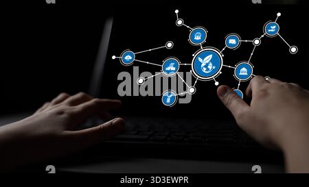 A close-up view of hands interacting with a laptop screen displaying icons that represent digital connectivity, technology, and global communication Stock Photo