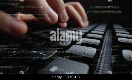 A close-up view of hands actively typing on a sleek keyboard. Background features streams of code reflecting the dynamic nature of software Stock Photo