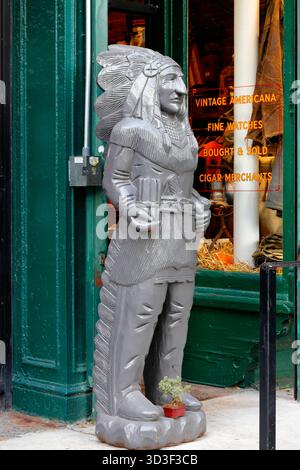 A Cigar Store Indian, wooden Native American, advertisement display, caricature outside a store in Manhattan's East Village neighborhood. Stock Photo