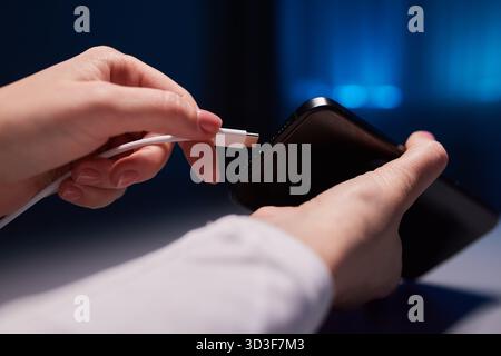 female Hand charges Charge your phone. Close up USB Type-C Stock Photo