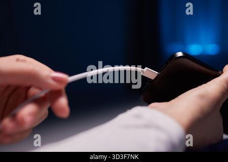 female Hand charges Charge your phone. Close up USB Type-C Stock Photo