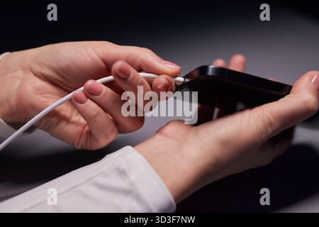 female Hand charges Charge your phone. Close up USB Type-C Stock Photo